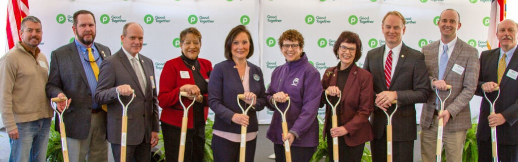 Group of executives holding shovels at groundbreaking event